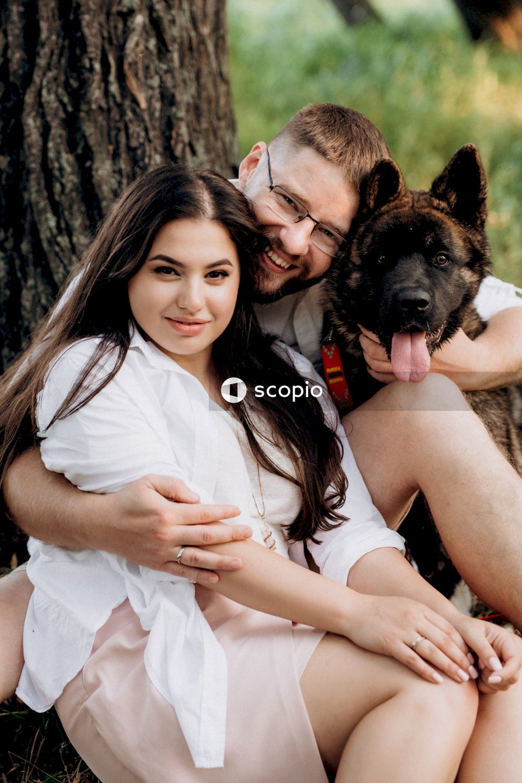 Woman in white shirt hugging black and tan german shepherd