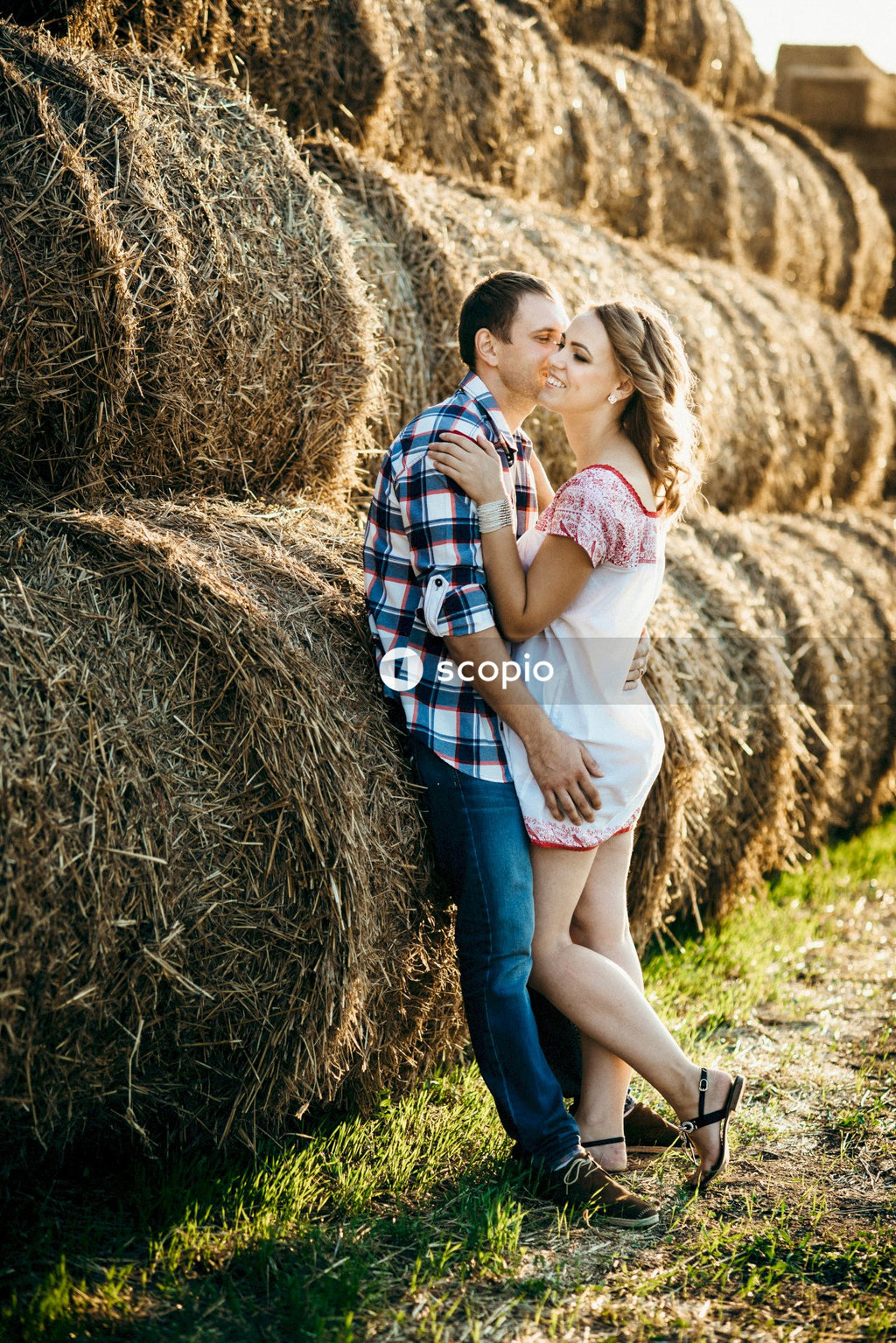 Woman in white shirt hugging man in blue and white plaid button up shirt