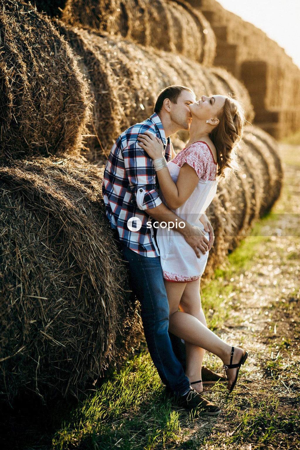 Woman in white shirt hugging woman in blue and white plaid dress shirt