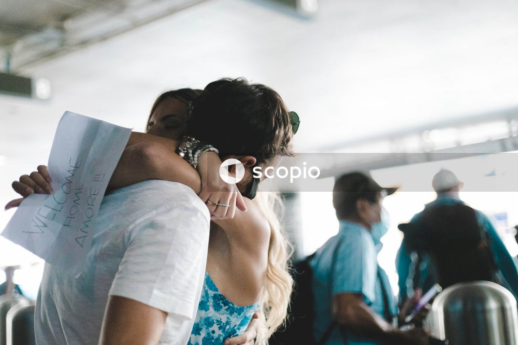Woman in white shirt kissing woman in blue and white floral shirt