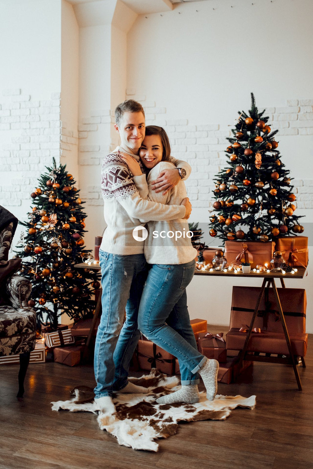 Woman and woman hugging beside Christmas tree at home