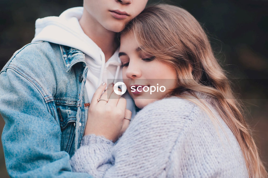 Woman in white sweater hugging woman in blue denim jacket
