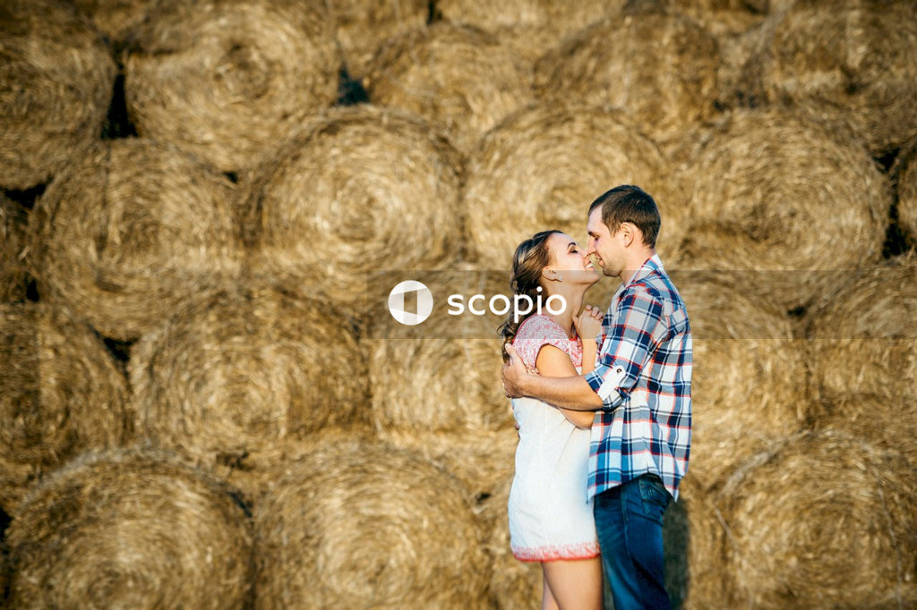 Woman in white tank top and blue denim shorts hugging man in blue and white plaid