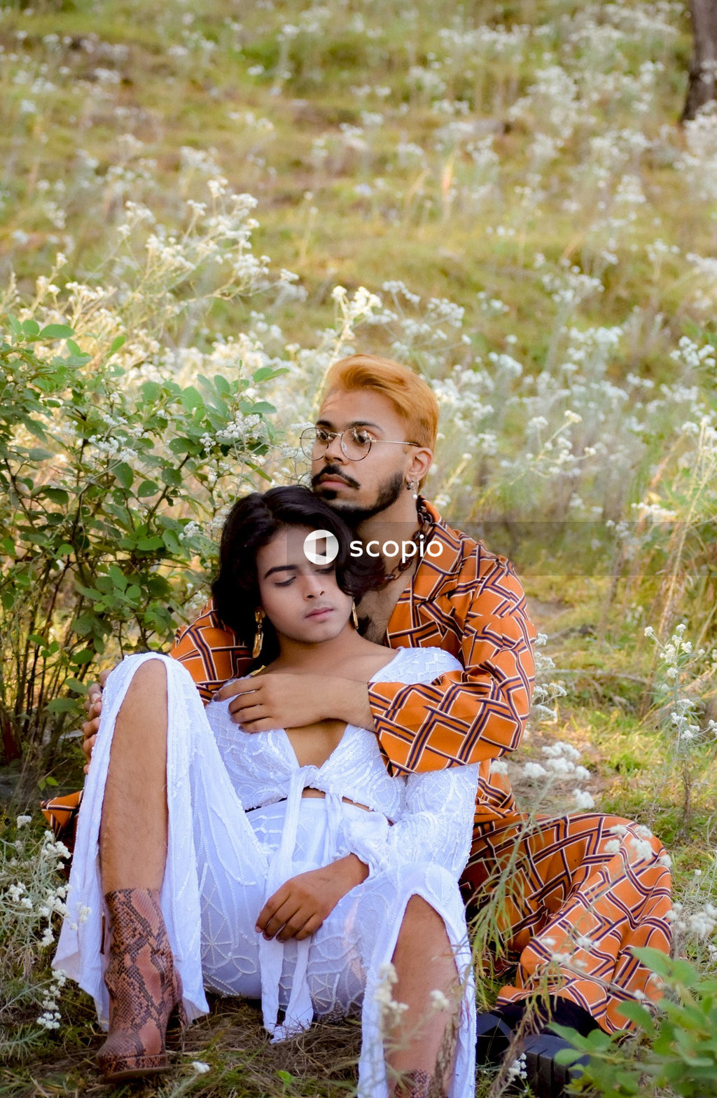 Two genderqueer man in stylish outfits having romantic moments outdoor in the nature