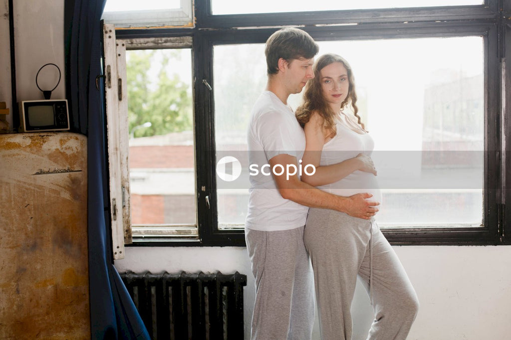 Couple standing next  to a glass window