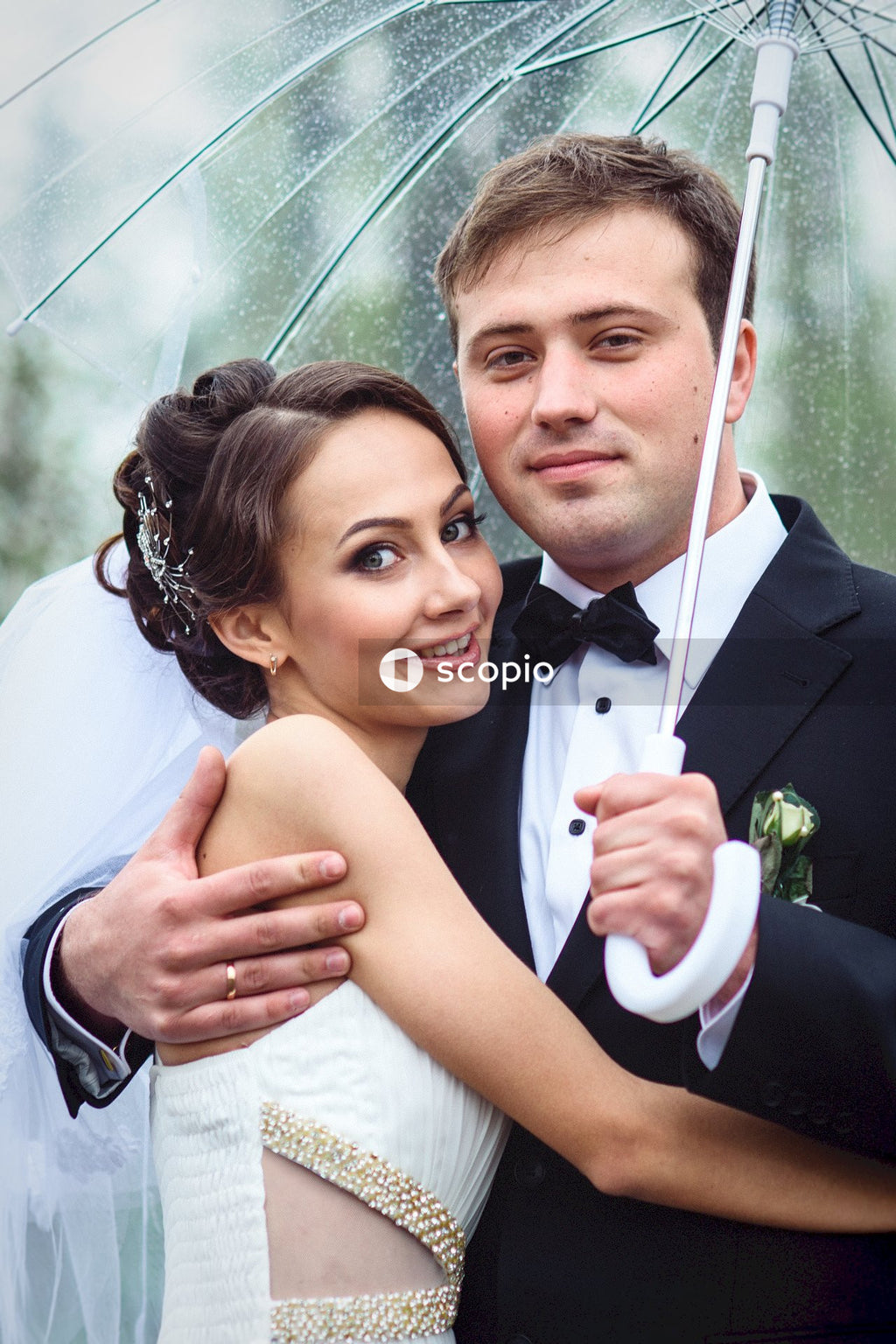 Woman in white tube dress hugging man in black suit