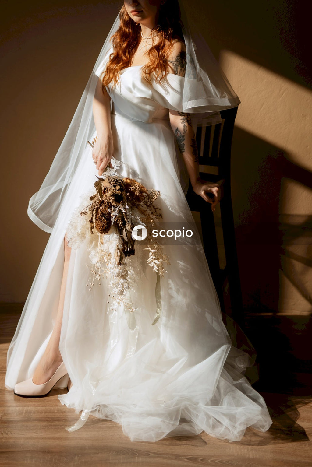 Woman in white wedding dress holding bouquet of flowers