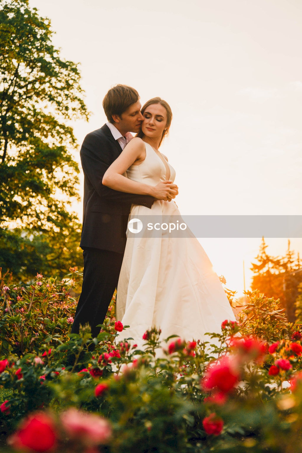 Woman in white wedding dress hugging man in black suit