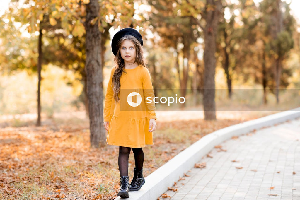 Woman in yellow long sleeve dress standing on pathway