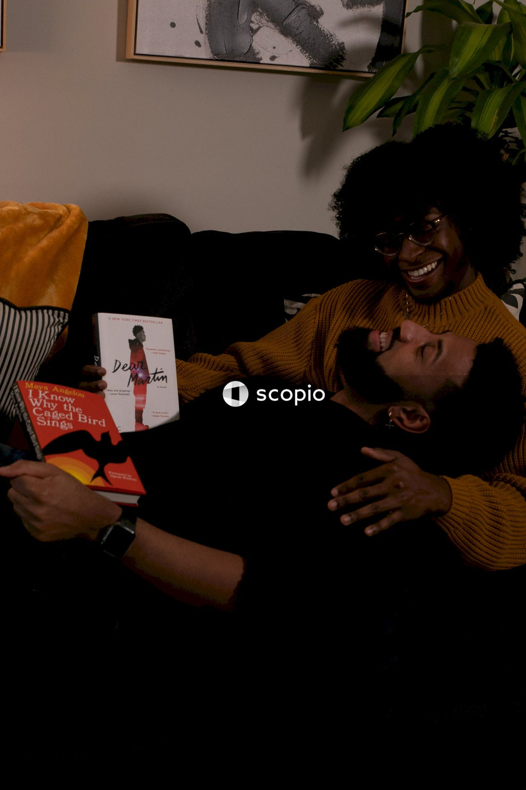 Couple sitting on the couch holding books