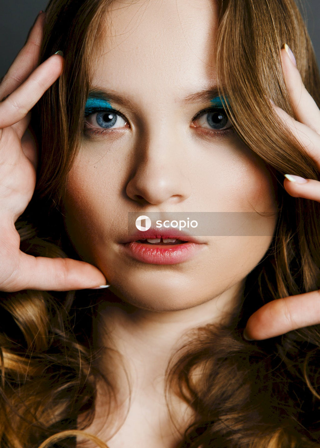 Woman with blonde hair holding her hair