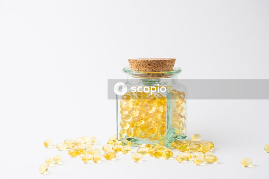 Yellow and white medication pill in clear glass jar