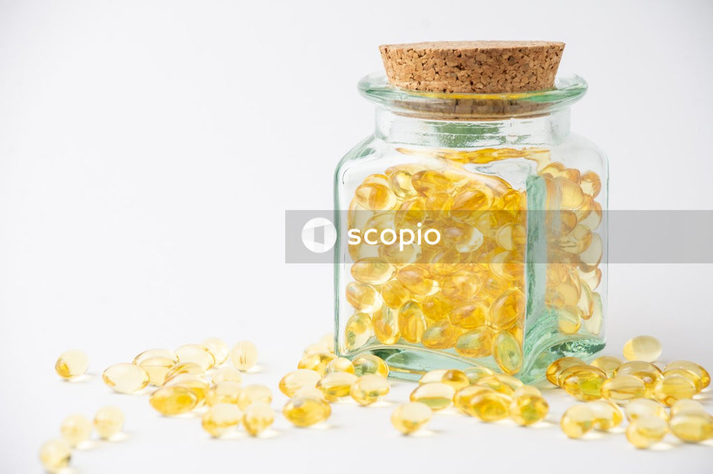 Yellow and white round medication pill in clear glass jar