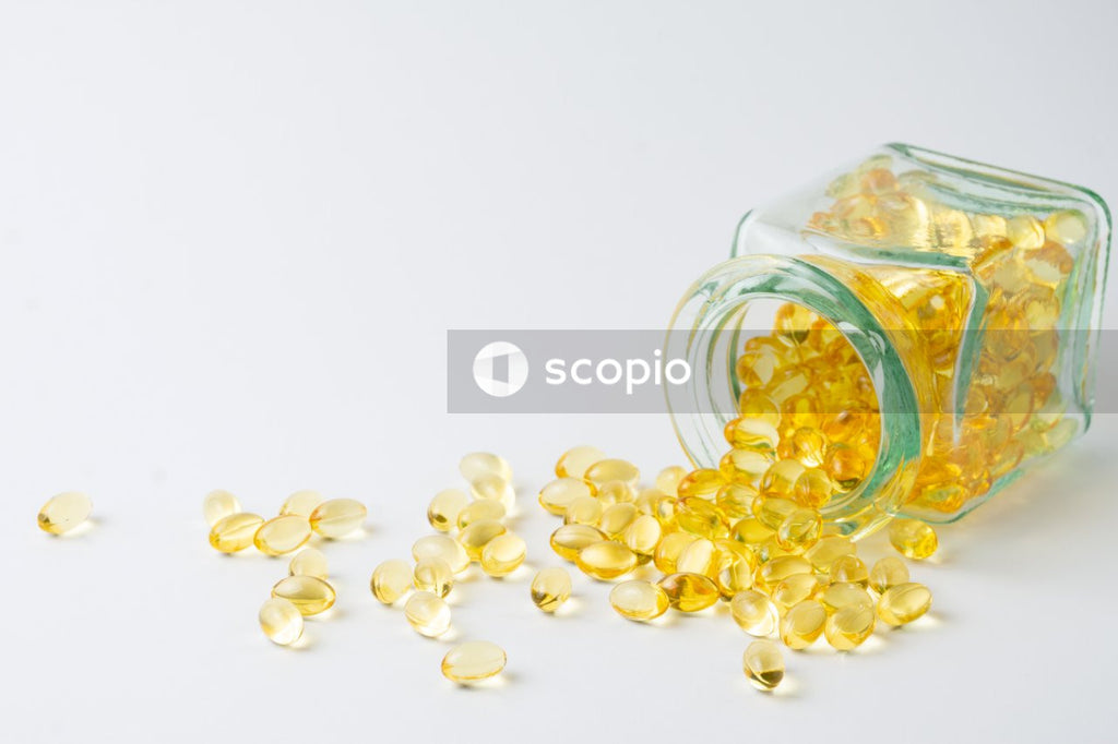 Yellow medication tablets in clear glass jar