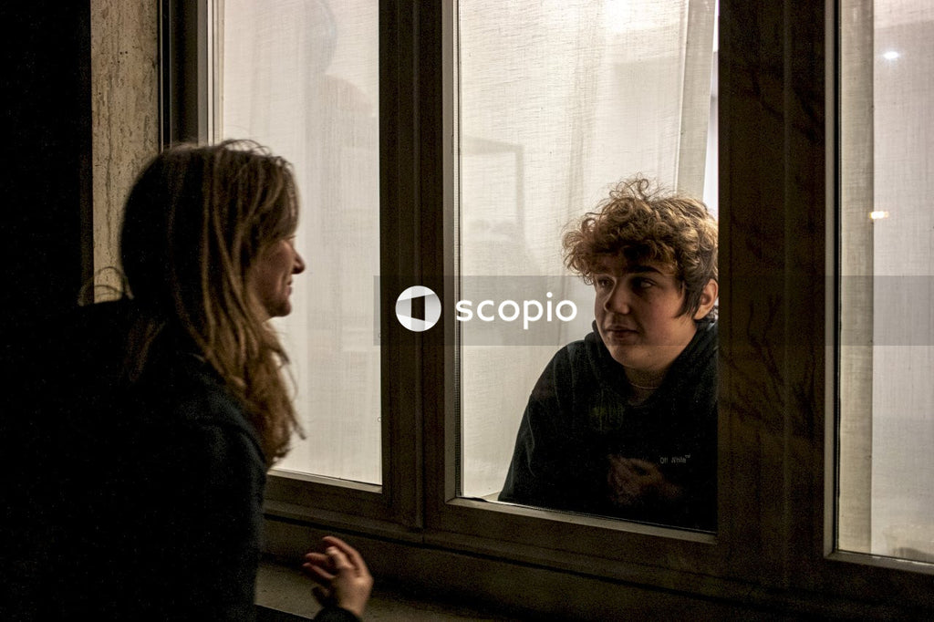 Young woman looking at quarantined young man during coronavirus pandemic
